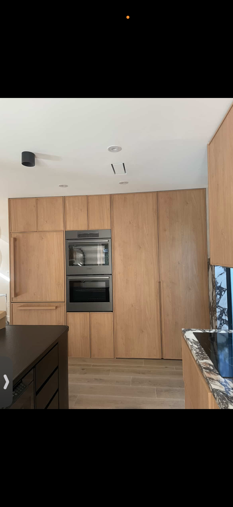 Warm oak kitchen with integrated ovens and Calacatta viola countertop