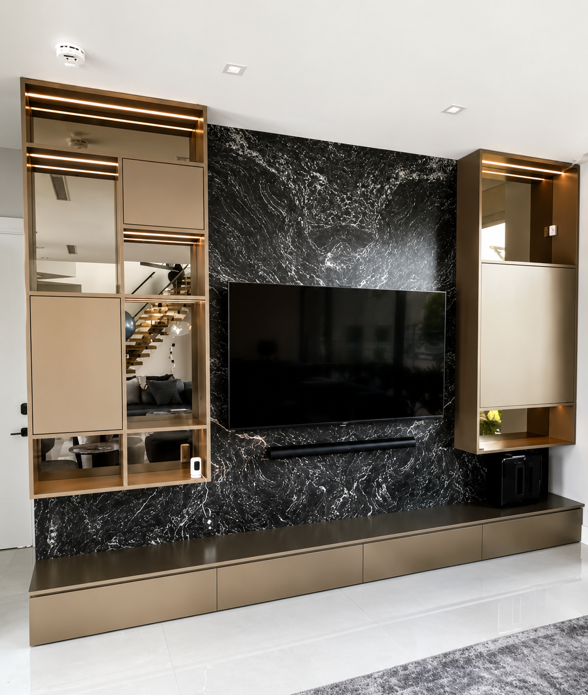 Dramatic media wall in book-matched dark granite framed by bronze-mirror display cabinets
