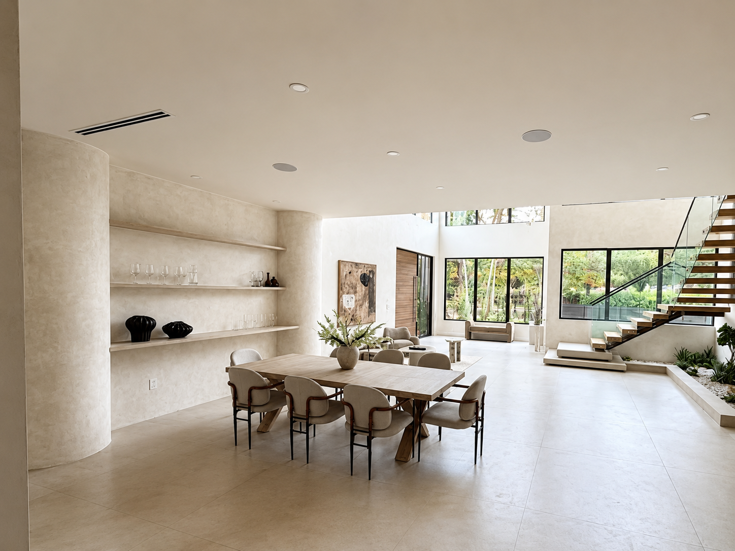 Double-height dining space in warm plaster with floating shelves and oak staircase