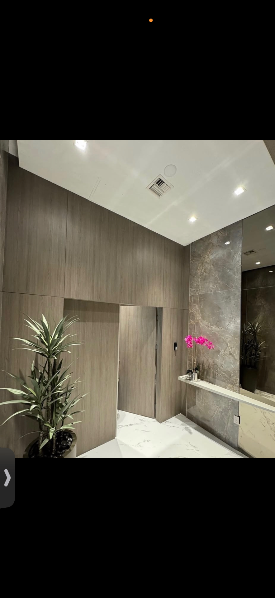 Powder area with woodgrain paneling and marble accent wall