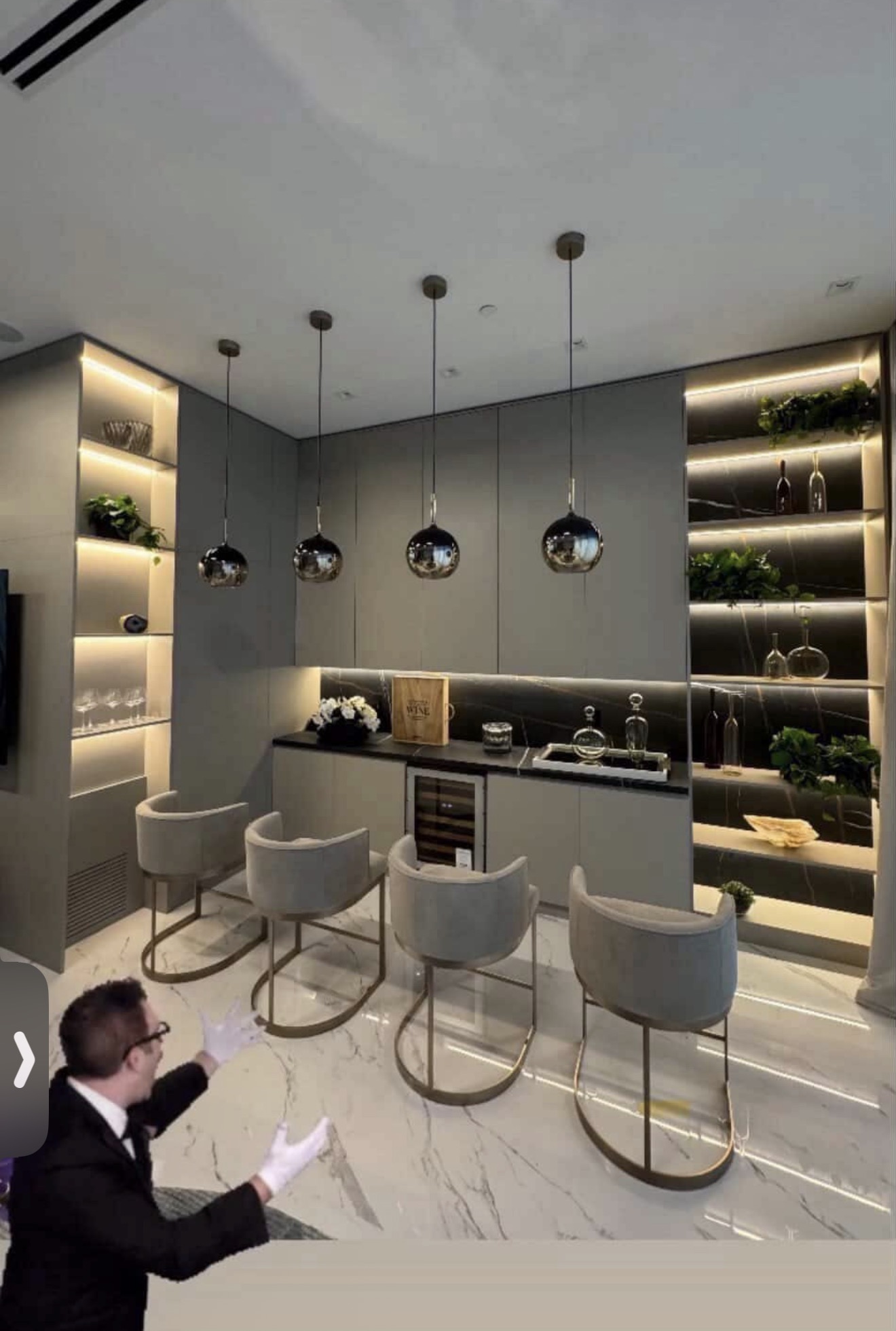 Wet bar with mirrored sphere pendants and lit stone shelving