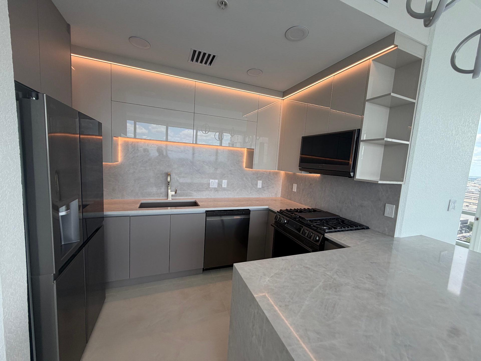Modern gray kitchen with high-gloss cabinetry and marble backsplash