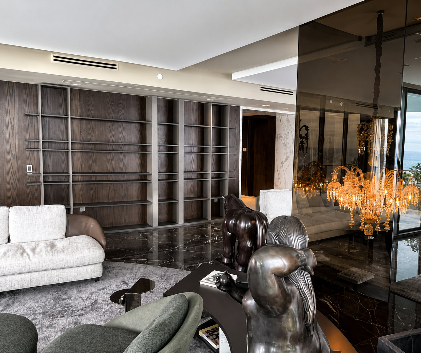 Living room with dark oak floor-to-ceiling shelving and marble floor