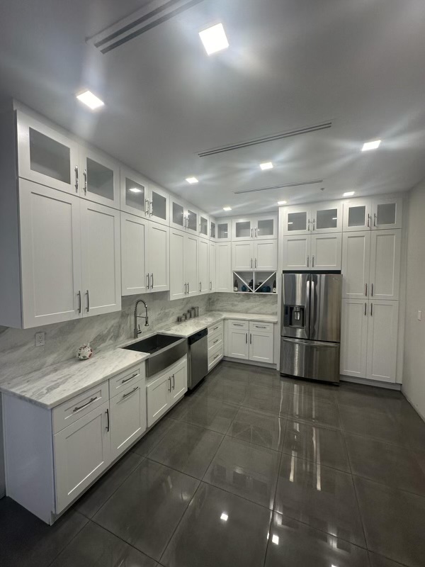 Bright white shaker kitchen with marble countertops and stainless appliances